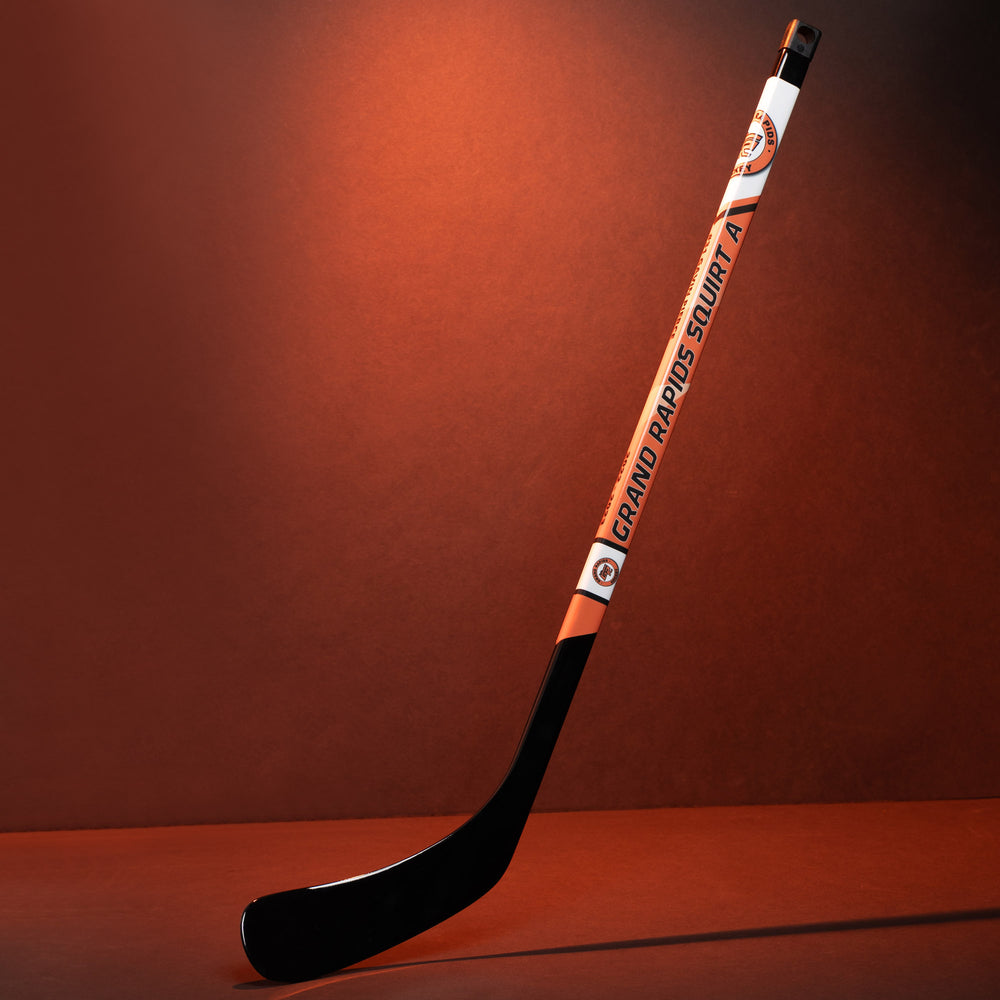 Full Grand Rapids sample mini hockey stick photographed on a warm orange background